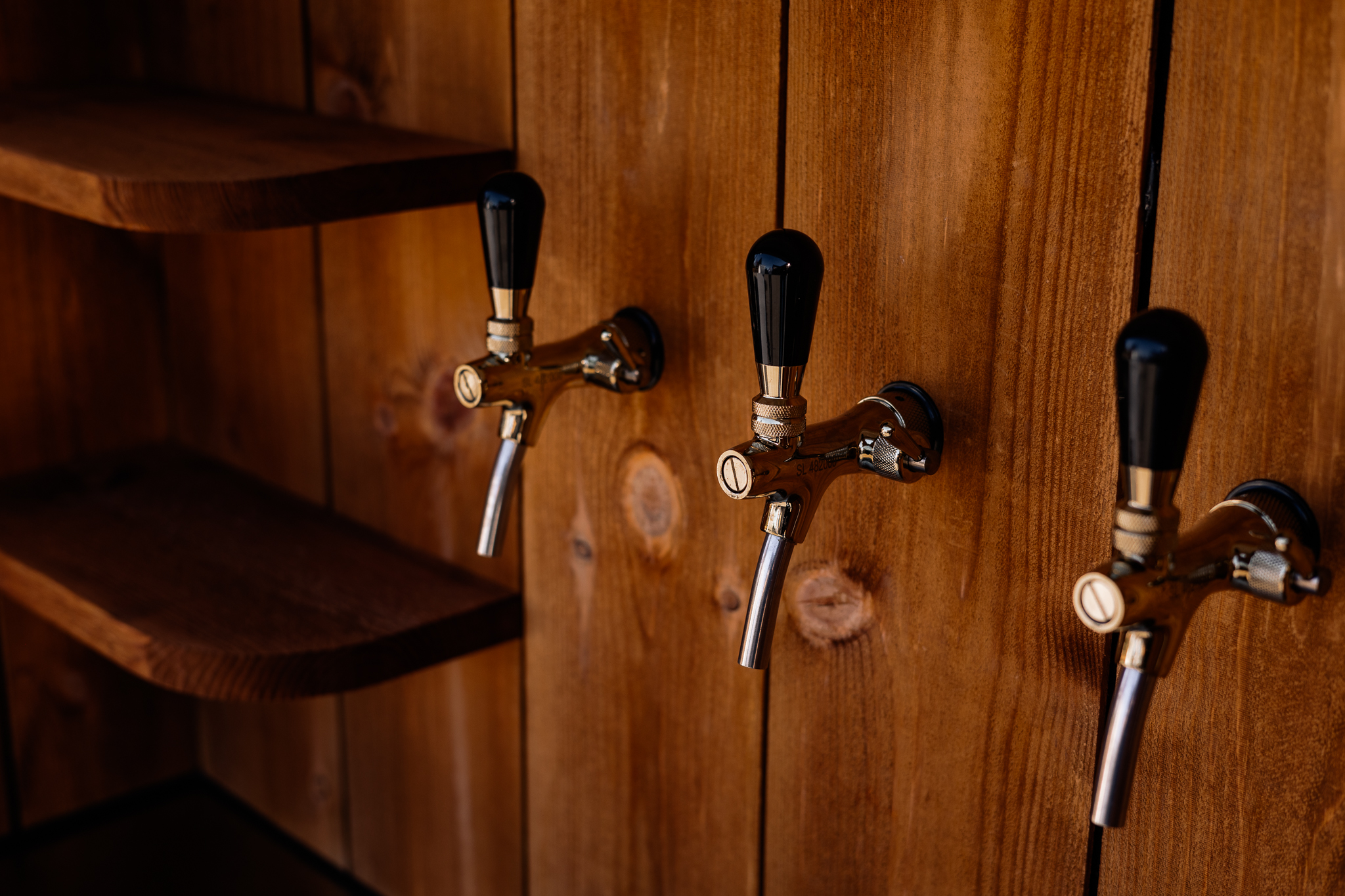 a row of taps on a wooden wall